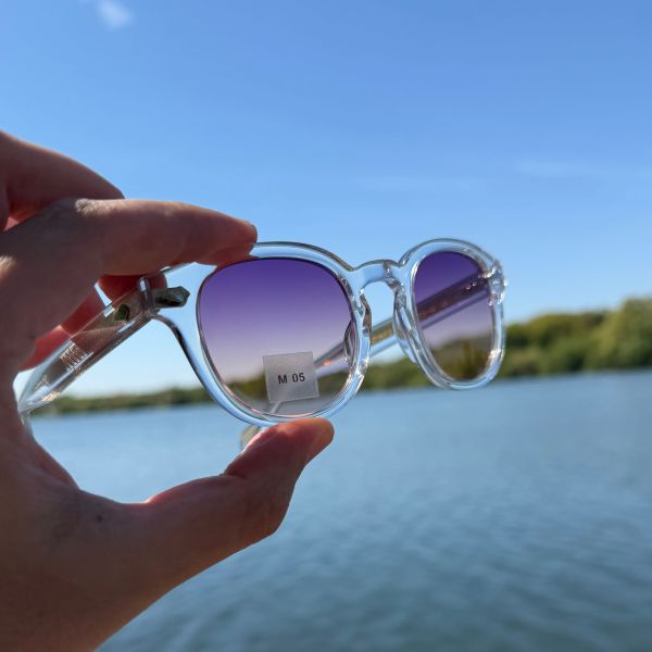Lunettes de soleil transparentes aux verres violets au bord de l’eau chez Optique Audition Suin Valenciennes