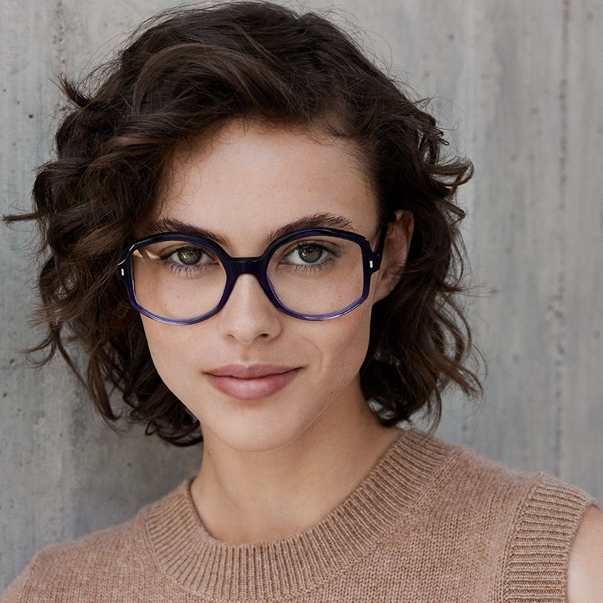 Découvrez la collection de lunettes de vue NUXE disponible sur notre boutique en ligne Femme portant des lunettes de vue NUXE bleues au style raffiné et féminin