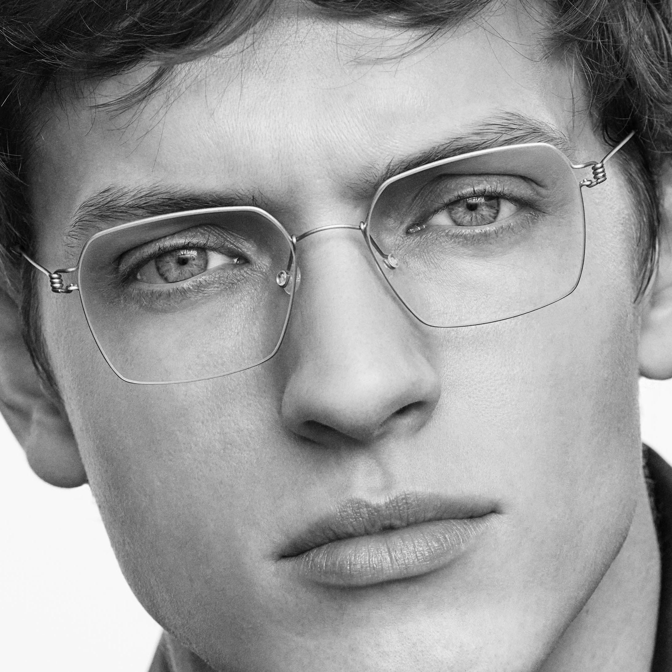 Lindberg : finesse du titane et élégance minimaliste Portrait noir et blanc avec lunettes Lindberg en titane ultra légères chez Optique Audition Suin Valenciennes