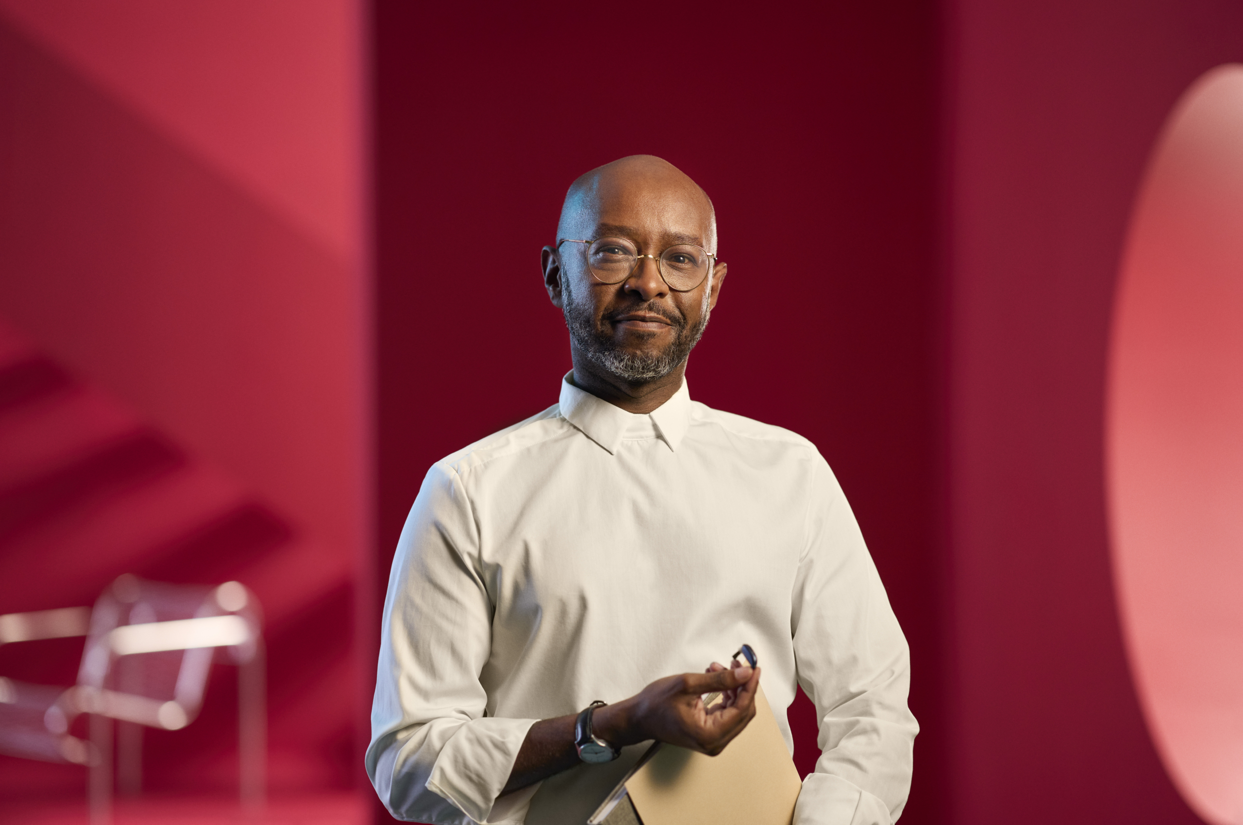 Portrait d’un homme tenant un appareil auditif, illustrant l’accompagnement personnalisé et la technologie auditive moderne